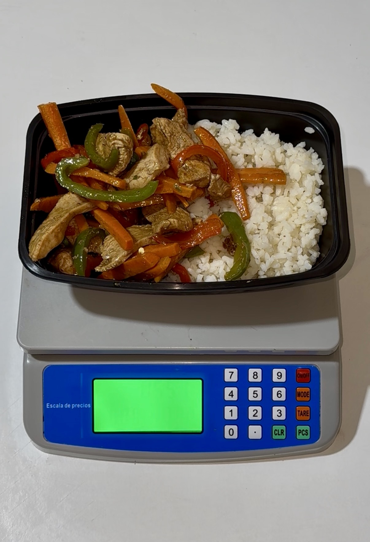 Pollo con verduras y arroz en un topper sobre nuestra báscula