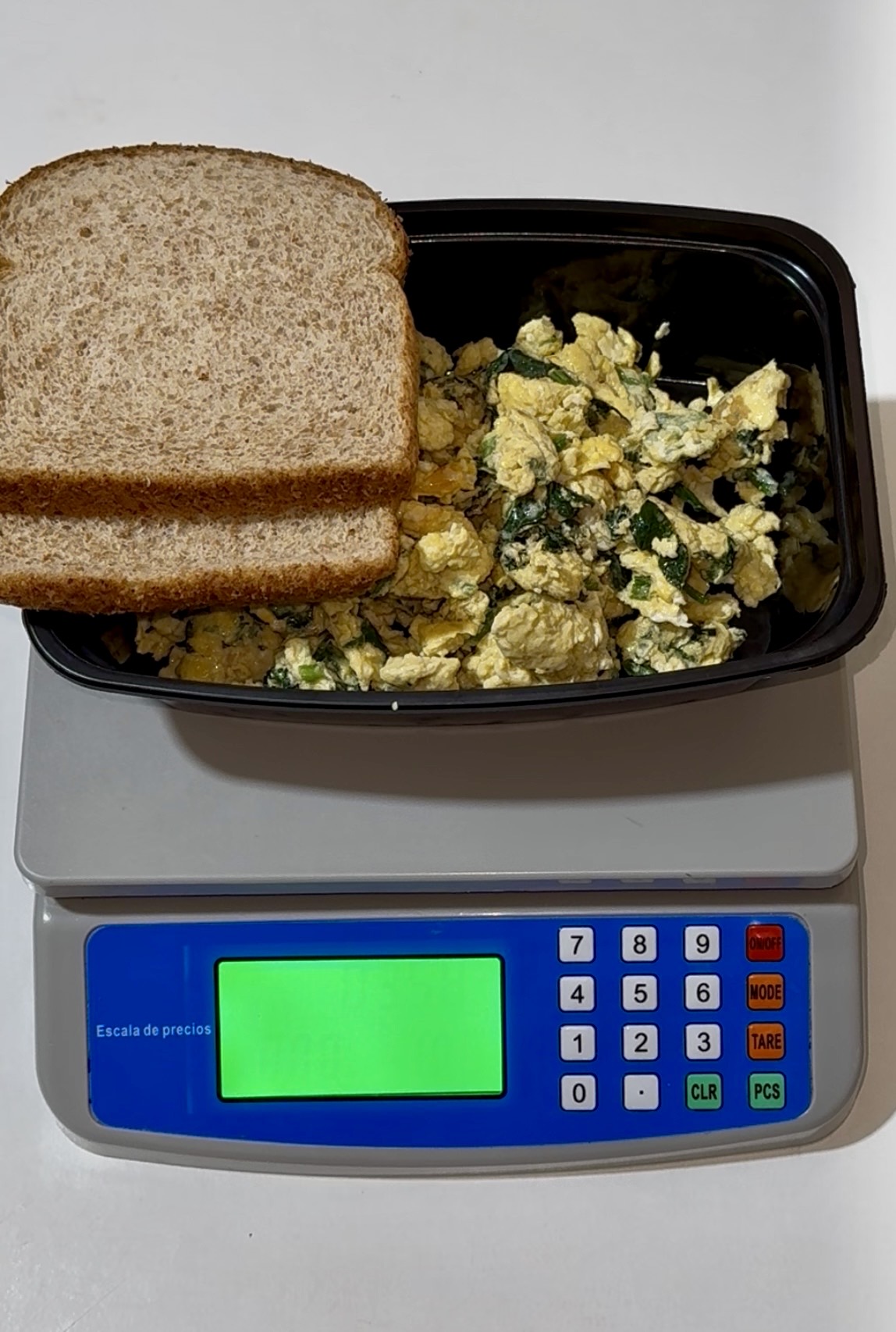 Huevos con espinaca y pan integral en un topper sobre nuestra báscula